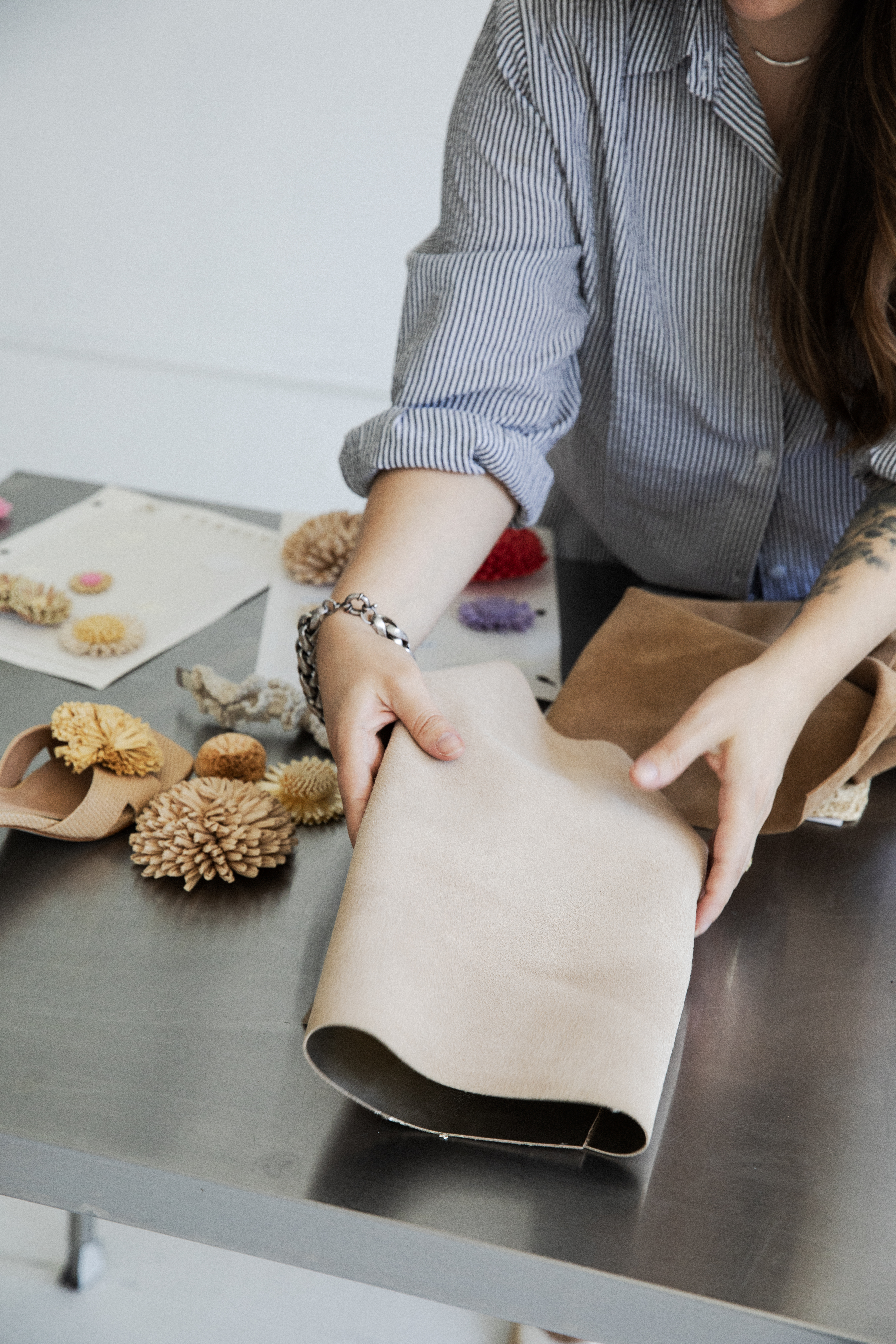 Erin Lavigne handling leather material swatches in the design studio