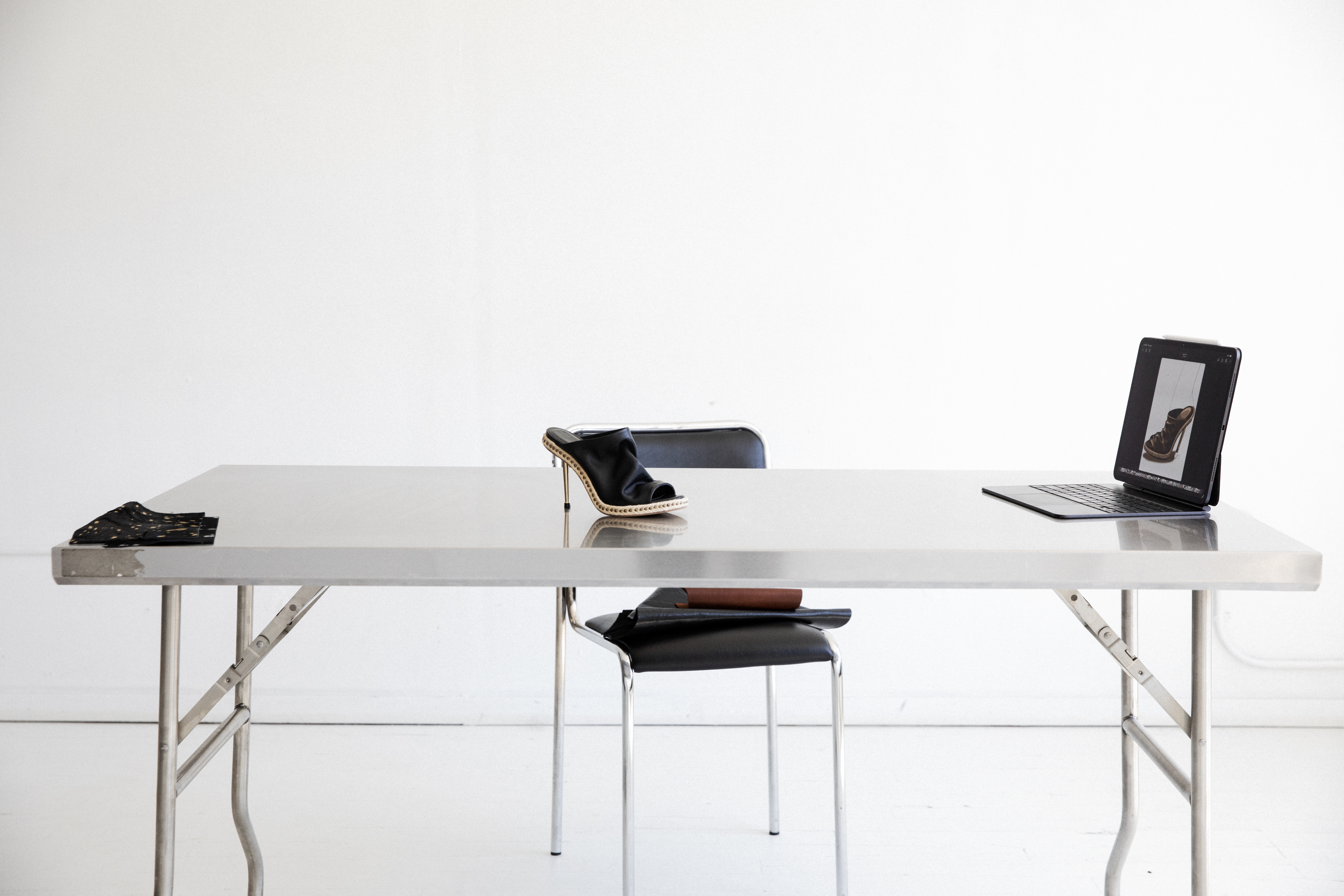 That Shoe Designer — the design studio table with a black studded mule heel and references