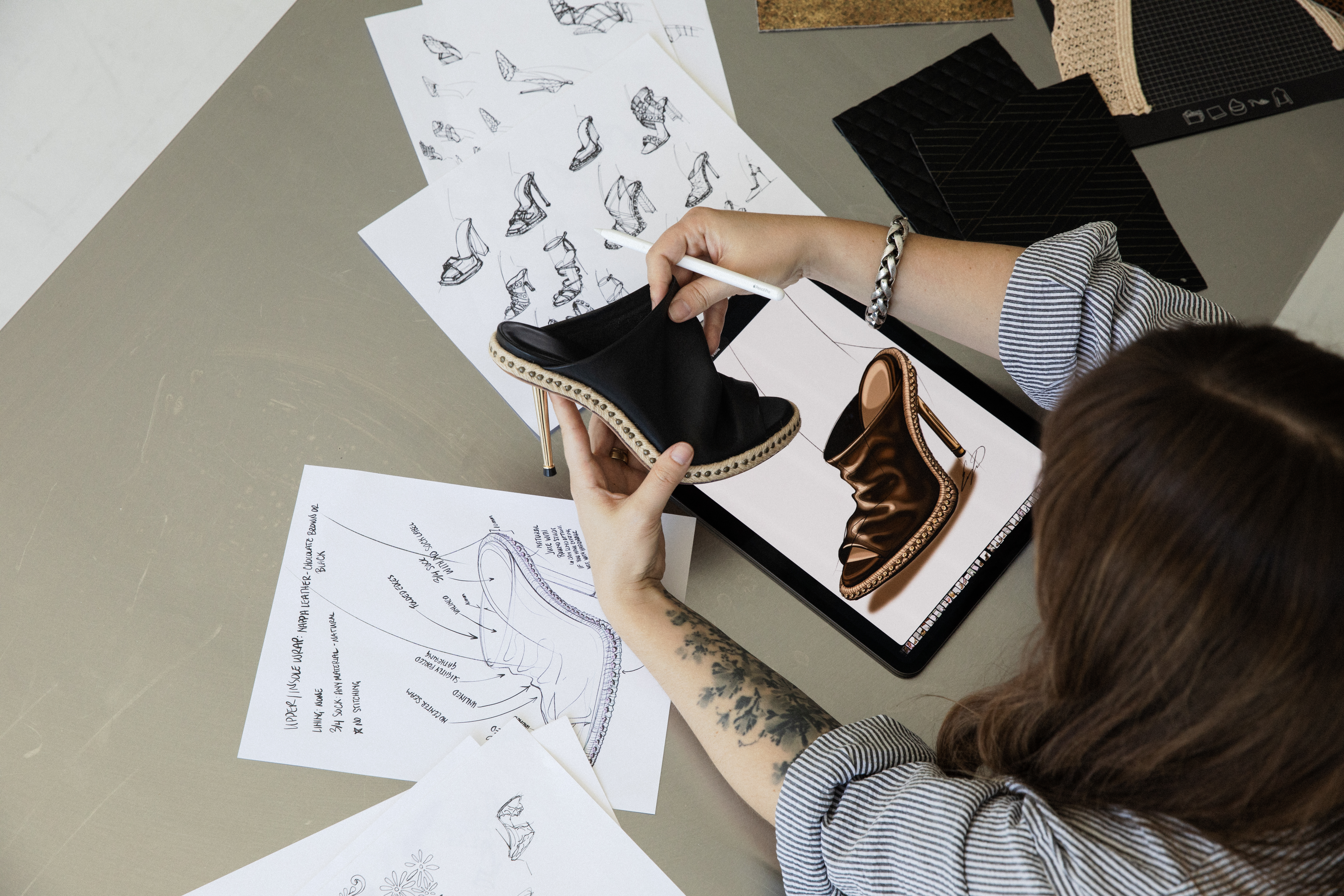 Overhead design session with prototype, sketches, and digital rendering on iPad